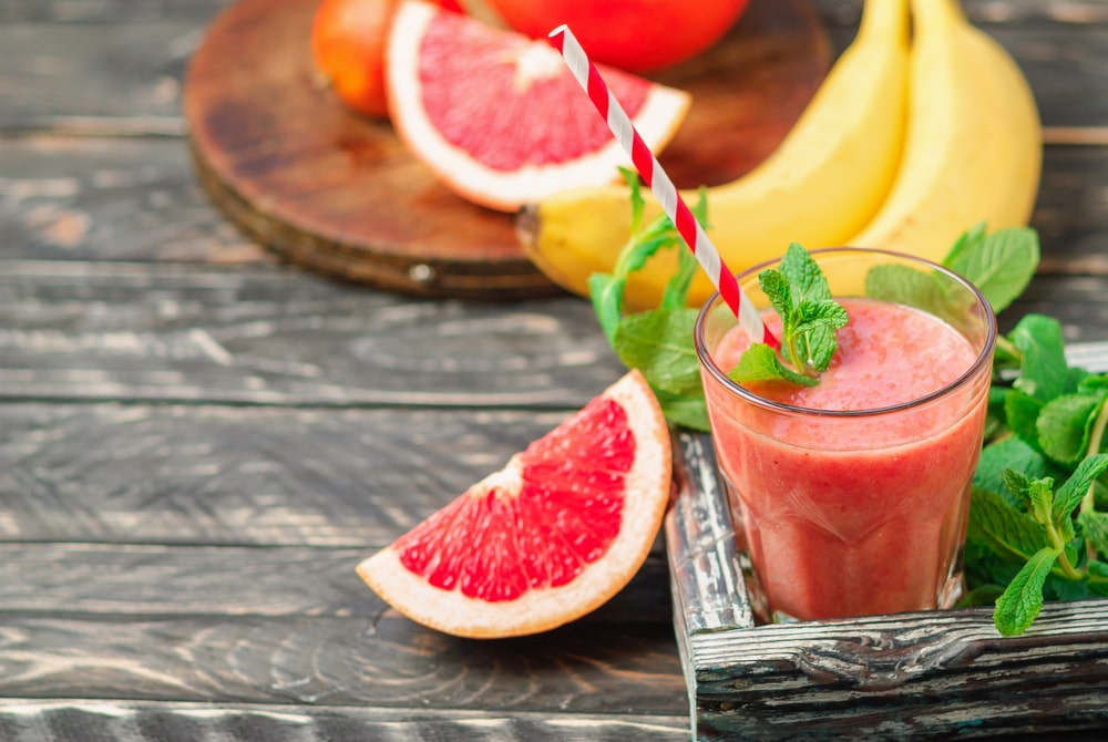 Smoothie z grapefrutiu a banánu ve sklenici s lístkem máty